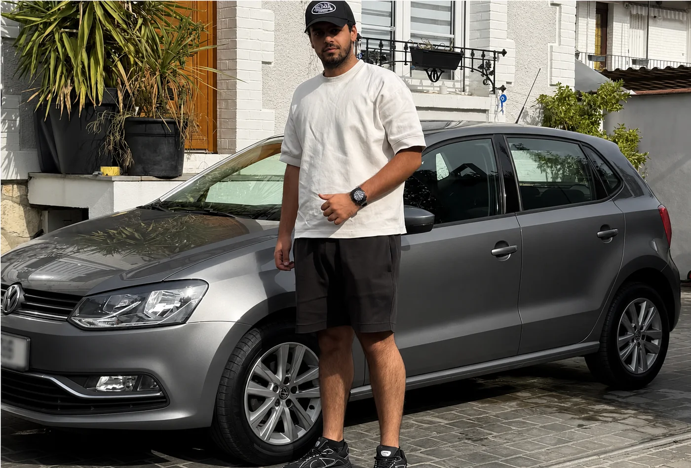 Un membre de RZ Motors devant une Volkswagen Polo grise